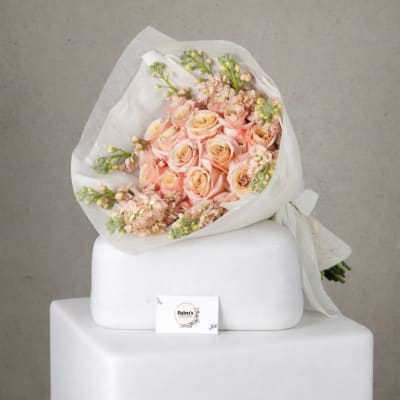 Bouquet of peach roses wrapped in white paper