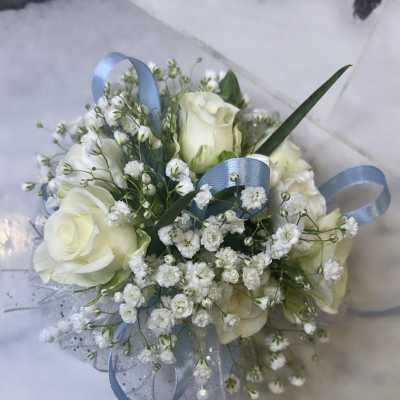 Small cluster of ivory roses and tiny white blooms with blue ribbon accents.