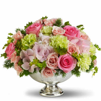 Pink and peach roses with green carnations in a silver pedestal bowl
