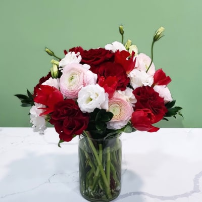 Bouquet of red and white flowers in a clear glass vase