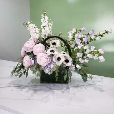 Pastel floral arrangement in a glass vase with pink, white, and lavender blooms