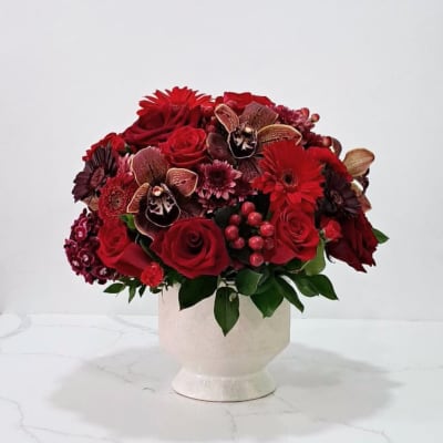 Red rose bouquet in a cream pedestal vase