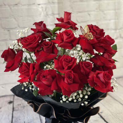 Bouquet of red roses with baby's breath in black wrap