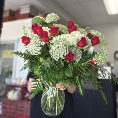 Bouquet of red roses and white flowers in a clear glass vase