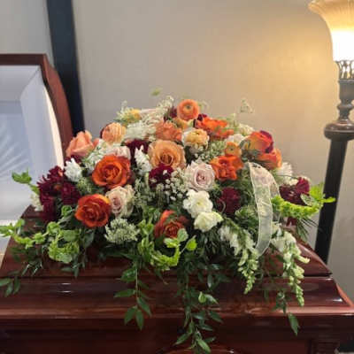 Large floral spray on a casket with orange and white roses