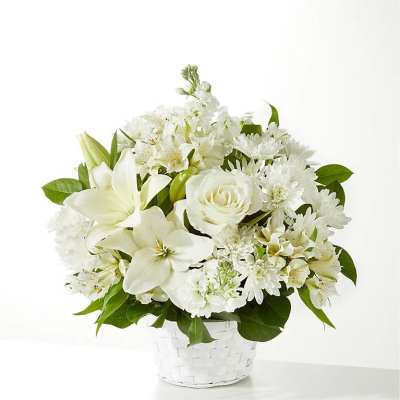 White floral arrangement in a white woven basket