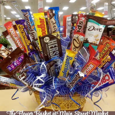 Basket arrangement of assorted candy bars with blue ribbon