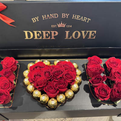 Red roses and chocolates arranged in a heart-shaped gift box
