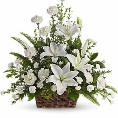 White lilies and carnations arranged in a wicker basket