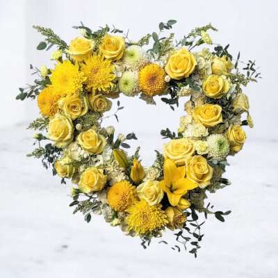Heart-shaped yellow floral arrangement with roses and mums