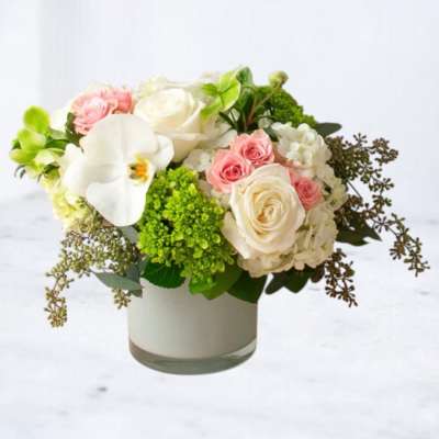 White and pink roses with a white orchid in a glass vase