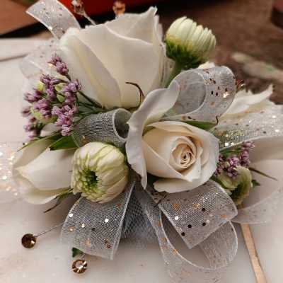 White rose corsage with small white blooms and silver ribbon