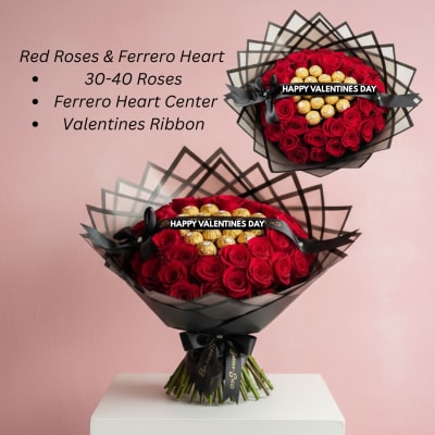 Large bouquet of red roses with gold-wrapped chocolates in a heart center, wrapped in black paper and ribbon