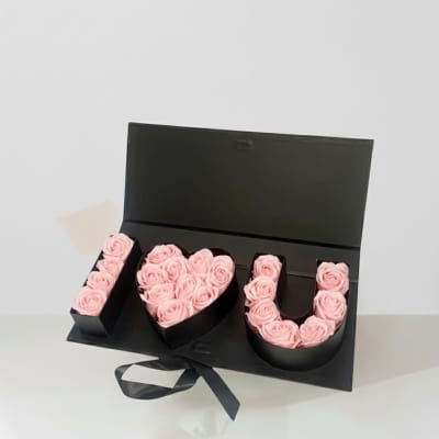 Pink roses arranged in a black box spelling "I ♥ U"