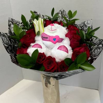 Bouquet of red roses with a white teddy bear in the center