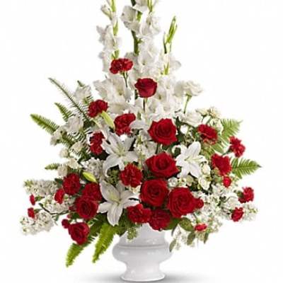 Red roses and white lilies in a white pedestal vase