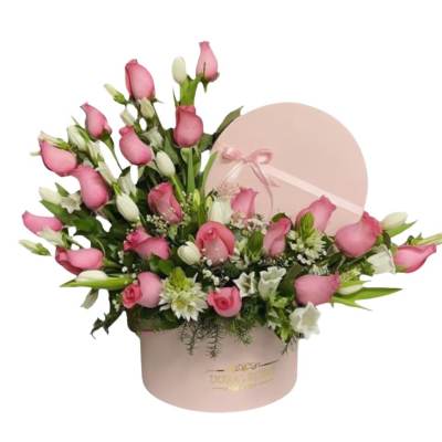 Pink roses and white flowers arranged in a round pink hat box