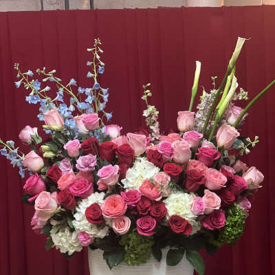 Large arrangement of pink and red roses in a white vase