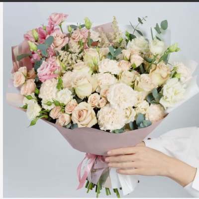 Large bouquet of pale pink and white roses with ribbon wrap