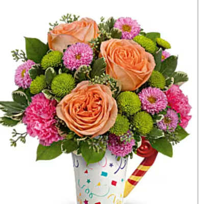 Bouquet of peach roses and pink flowers in a decorated cup
