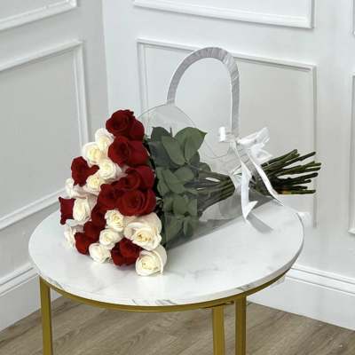 Bouquet of red and white roses wrapped in clear plastic with a white ribbon