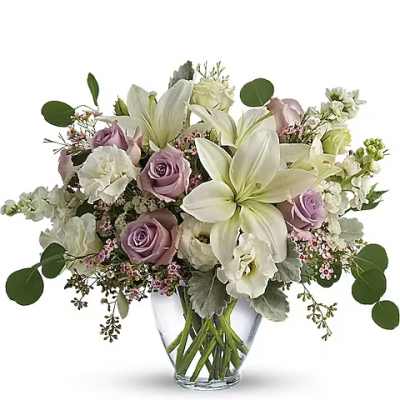 White lilies and lavender roses in a clear glass vase
