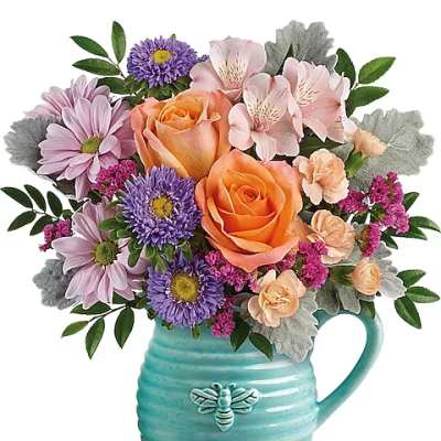 Bouquet of orange roses, pink alstroemeria, and purple daisies in a turquoise mug vase