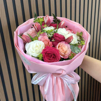 Pink bouquet of roses and tulips wrapped in pink paper
