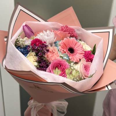 Pink mixed flower bouquet wrapped in pastel paper
