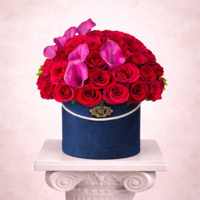 Red rose arrangement with pink calla lilies in a blue hatbox