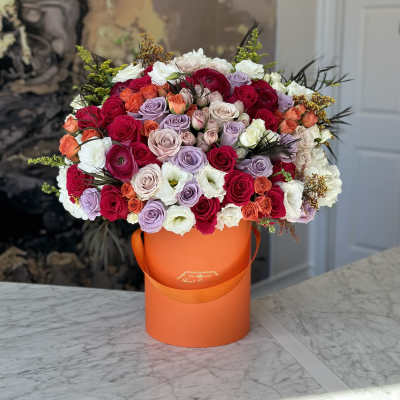 Large mixed rose bouquet in an orange hatbox