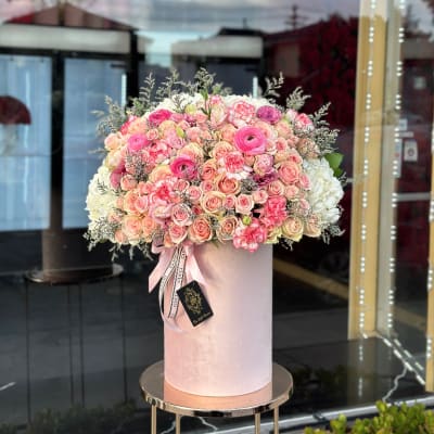Large pink and white rose arrangement in a tall blush box