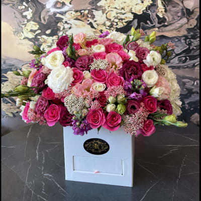 Large bouquet of pink, white, and purple roses in a white box