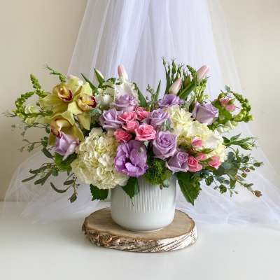 Lavender and pink floral arrangement in a white vase