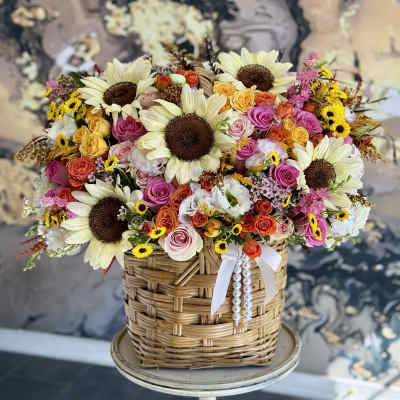 Basket arrangement of sunflowers and multicolored roses