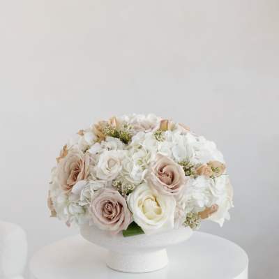 Blush and white roses with white hydrangeas in a white pedestal vase