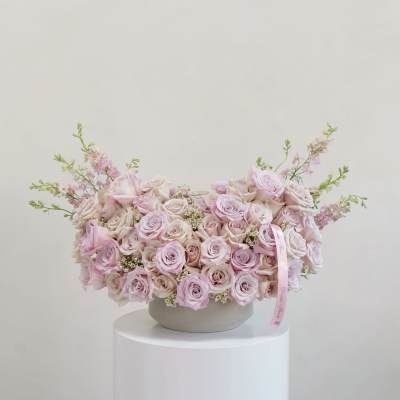 Large pastel pink rose arrangement in a round vase