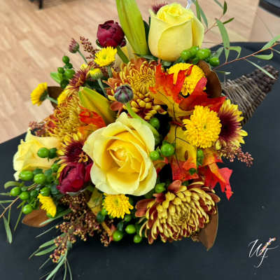 Bouquet of yellow roses and autumn flowers with leaves and berries