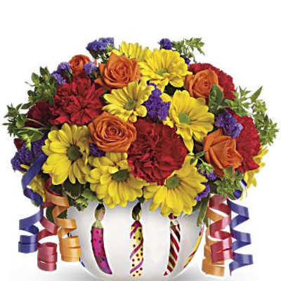 Colorful bouquet of roses and daisies in a white vase with curling ribbons