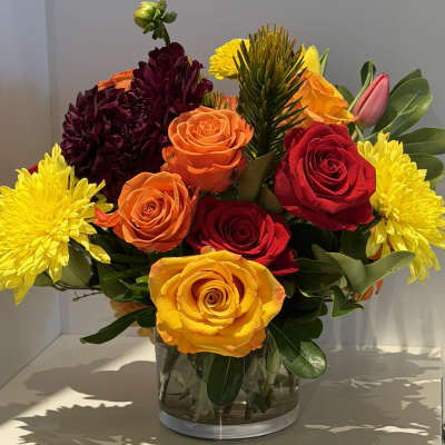 Mixed bouquet of roses and chrysanthemums in a clear glass vase