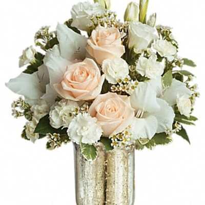 Peach roses and white flowers in a gold vase