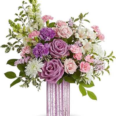 Pink and purple floral arrangement in a ribbed glass vase
