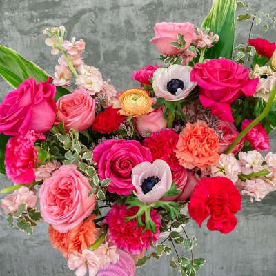 Handheld bouquet of pink and red roses with mixed blooms
