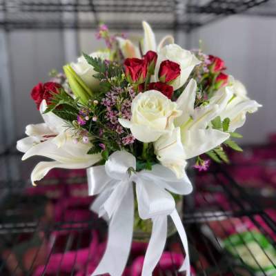Bouquet of white lilies and red roses with a white ribbon