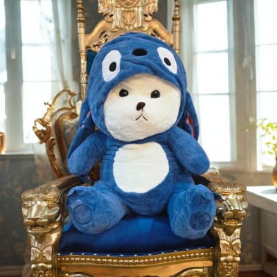 Blue plush bear sitting on an ornate gold chair