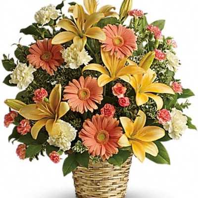 Basket arrangement with yellow lilies, peach daisies, and carnations
