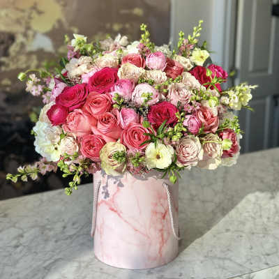 Pink and cream rose bouquet in a marble-patterned hat box