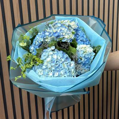 Blue hydrangea bouquet wrapped in turquoise paper