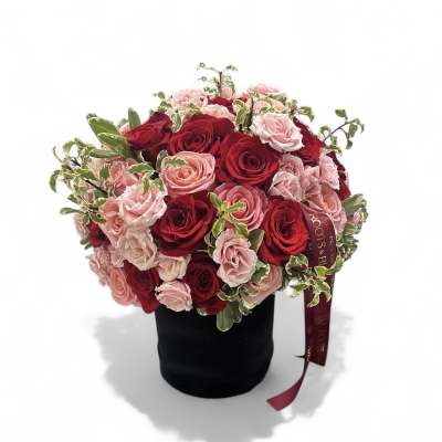 Bouquet of red and pink roses in a black hatbox