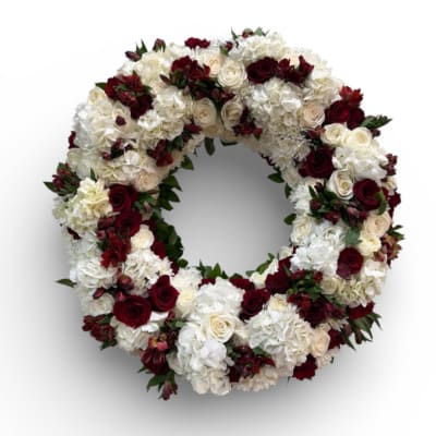 Circular floral wreath of white and deep red flowers